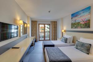 a hotel room with two beds and a flat screen tv at Diamond Of Bodrum in Bodrum City