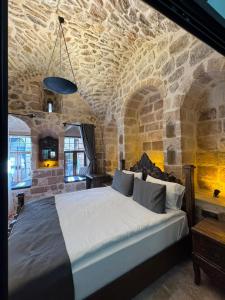 a bedroom with a large bed in a stone room at Sıla Konağı Hotel in Mardin