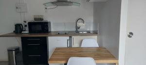 a small kitchen with a wooden table and chairs at Studio cosy in Écouflant +9 photos