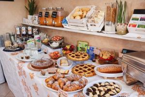 a table topped with lots of pastries and other foods at Hotel Villa Gioiosa - Beach & Bistrot in Rimini