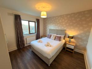 a bedroom with a large white bed with a window at Cois Cairn in Dingle