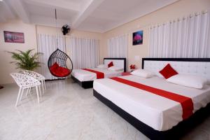 a hotel room with two beds and a chair at Skylark Home in Mananthavady
