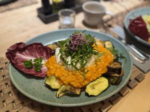 a blue plate of food on a table at Weissenfelder Guest House & Restaurant in Weißenfeld +9 photos