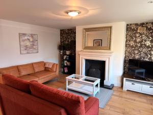 a living room with a couch and a fireplace at Cois Cairn in Dingle
