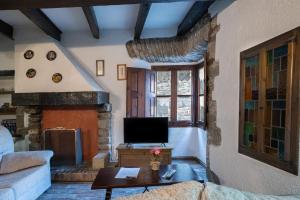 a living room with a couch and a tv at Apartaments Can Lo in Rupit