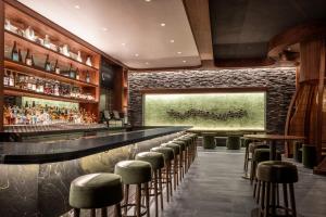 a bar with stools and a stone wall at Nobu Hotel New Orleans - A Caesars Rewards Destination in New Orleans +14 photos
