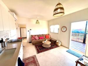 a living room with a couch and a table at Cabin 168 in Neot Golan