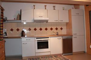 kuchnia z białymi szafkami i piekarnikiem w obiekcie Ferienwohnung Tummener w mieście Zell am Ziller