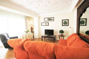 アリカンテにあるCasaTuris Pintor Lorenzo A105のリビングルーム(オレンジ色のソファ、テレビ付)