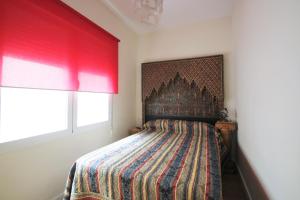 a bedroom with a bed with a colorful blanket at CasaTuris Pintor Lorenzo A105 in Alicante