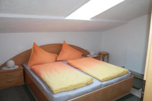 sypialnia z łóżkiem z pomarańczowymi i żółtymi poduszkami w obiekcie Ferienwohnung Tummener w mieście Zell am Ziller