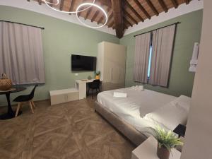 a bedroom with a bed and a desk and a tv at Il Podere Orto in San Gimignano