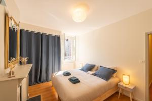 a bedroom with a large white bed with blue pillows at Le St Géraud, 3 chambres, Prémium avec Fibre, Centre Aurillac in Aurillac