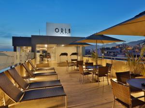 a rooftop deck with tables and chairs and an outdoor restaurant at Orla Copacabana Hotel in Rio de Janeiro