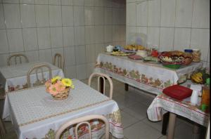uma sala de jantar com duas mesas e pratos de comida em Hotel Pousada João 3.16 em Barretos