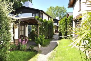 a yard with a house and a garden with flowers at Cabañas Patagonia in Villa Gesell