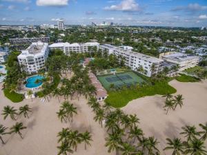 an aerial view of a resort with a tennis court and palm trees at The Lago Mar Beach Resort and Club in Fort Lauderdale