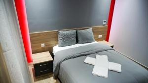 a bedroom with a bed with two white crosses on it at P & K Design LTD Flats in Nea Moudania