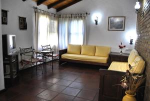 un soggiorno con divano giallo e tavolo di Cabañas Patagonia a Villa Gesell