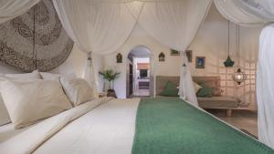 a bedroom with a large white bed with curtains at Mondo Surf Village in Canggu