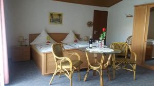 a room with a table and chairs and a bed at Gästehaus-Weingut Michael Scholer in Schleich