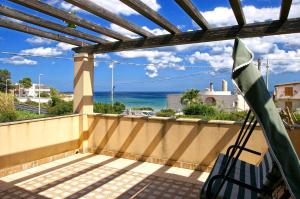 a hammock on a balcony with a view of the ocean at Villa Mare Noto Marina in Noto Marina
