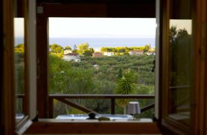a window view of the ocean from a house at Villa Belvedere - Panoramic Sea View apts in Vasilikos