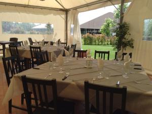 a set of tables in a tent with white table cloth at La Scuderia in Sarzana
