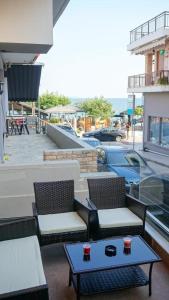 a patio with two chairs and a table with cups on it at P & K Design LTD Flats in Nea Moudania
