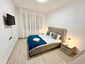 a bedroom with a bed with a blue blanket at JAD Apartments - Isaran & Maurer in Braşov