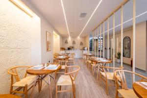 a row of tables and chairs in a restaurant at Aether Athens Urban Hotel in Athens