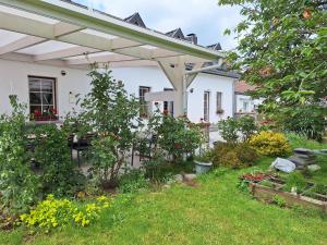 a white house with a garden in front of it at Le Monciat in Lessines
