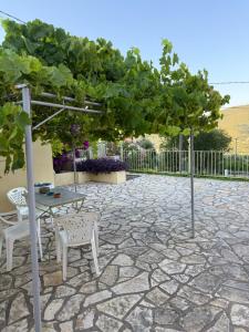 a patio with a table and chairs under a tree at Alkyonis House in Platithriás