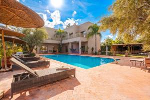 a home with a swimming pool and a house at Dar Fatima Tamazouzt in Marrakesh
