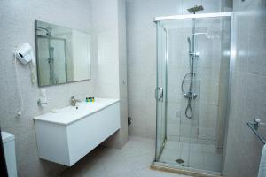 a bathroom with a shower and a sink and a glass shower stall at Nemi Boutique Hotel in Baku