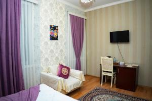a hotel room with a bed and a chair and a desk at Nemi Boutique Hotel in Baku