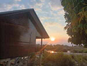 a building with the sunset in the background at Thiptavanh guesthouse in Don Det
