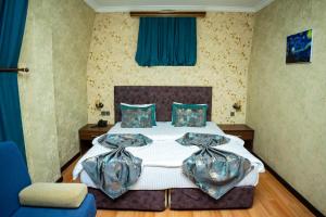 a bedroom with a large bed with blue drapes at Nemi Boutique Hotel in Baku