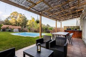 a patio with a table and chairs and a pool at O Lar de Laura Casa familiar para escapada tranquila con piscina y sala de juegos cerca de Vigo in Vigo