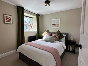 a bedroom with a bed with pillows and a window at Riverview House in Minnigaff