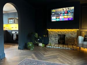 a living room with a fireplace with a television above it at Riverview House in Minnigaff