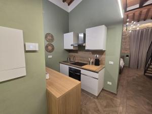 a kitchen with white cabinets and a sink at Il Podere Orto in San Gimignano