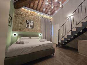 a bedroom with a large bed and a staircase at Il Podere Orto in San Gimignano