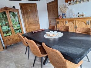 a dining room with a black table and chairs at Le Monciat in Lessines