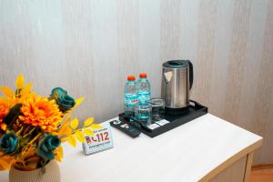a table with a coffee maker and flowers on it at Nemi Boutique Hotel in Baku +85 photos