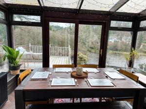 a wooden table in a room with a large window at Riverview House in Minnigaff