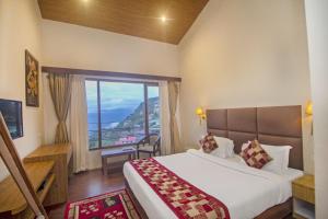 a hotel room with a bed and a large window at Royal Hotel Gangtok in Gangtok +37 photos