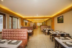 a dining room with tables and chairs in a restaurant at Royal Hotel Gangtok in Gangtok
