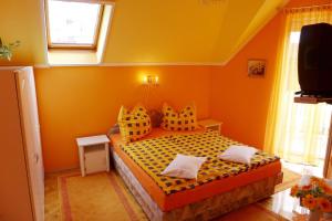 A bed or beds in a room at Caty Vendégház
