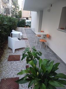 a patio with a white table and chairs and plants at Casa Vacanze Derby Appartamenti in Misano Adriatico